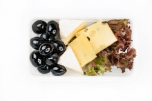 Cheese plate with salad and black olives